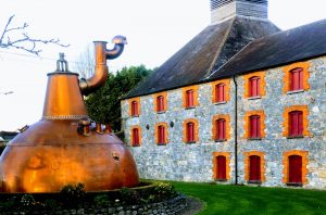 Edificio de destilería de whisky de piedra con gran alambique de cobre