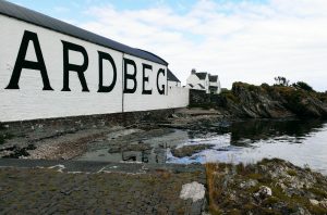 Vista de la destilería de whisky Ardbeg junto al mar con Seaview Cottage 