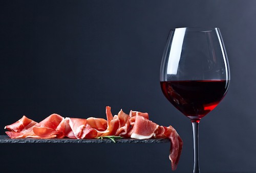 Beber vino con jamón es una actividad popular en Madrid.  Espere que le ofrezcan una copa de Rioja o Ribera cuando salte rápidamente de un restaurante a otro.