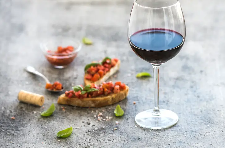 Copa de vino vegano maridado con comida en la mesa